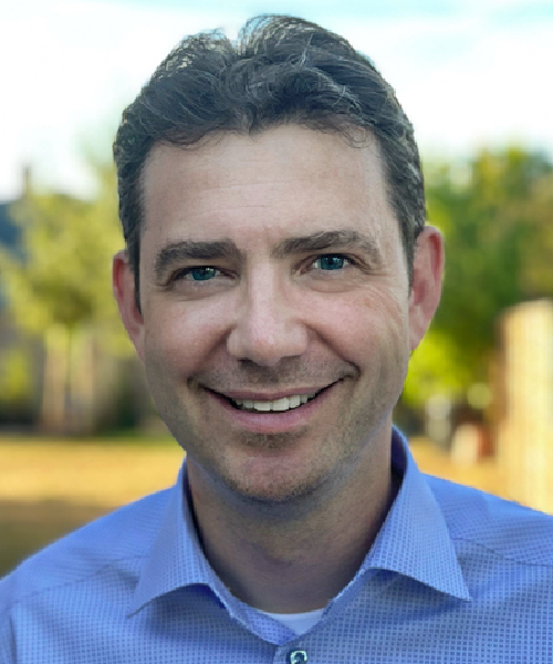 Photo de Sean Hardiman, FCCHL, souriant dans une chemise bleue.