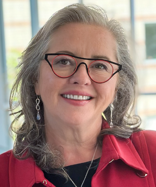 Photo de Susan Walsh, FCCHL, souriant dans un blazer rouge.